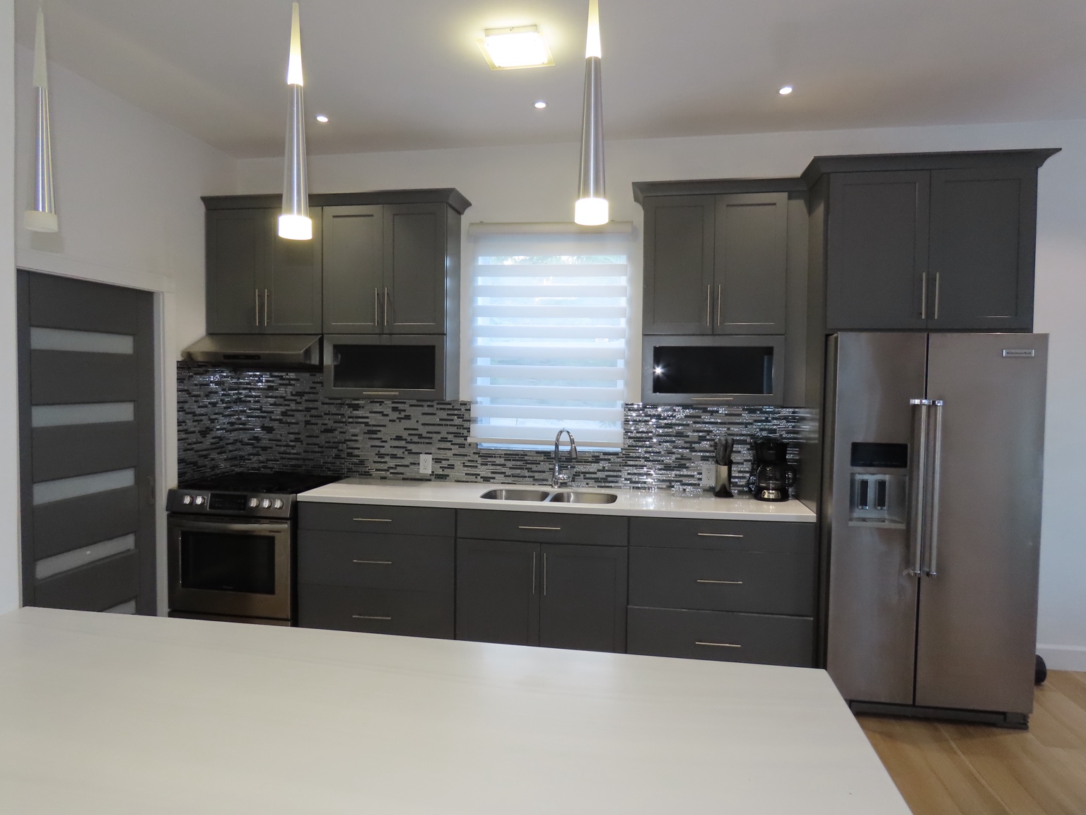 Guest house kitchen with dark cabinets, dining island and stainless appliances
