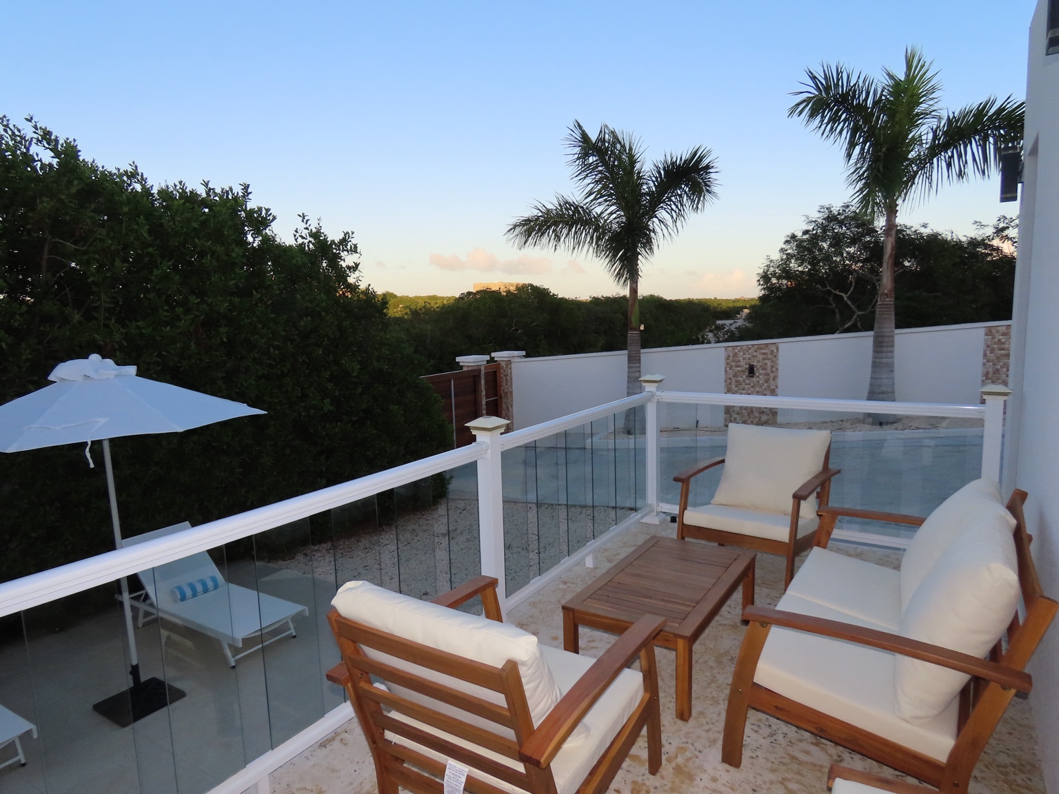 Upper terrace seating with palms and outdoor dining below