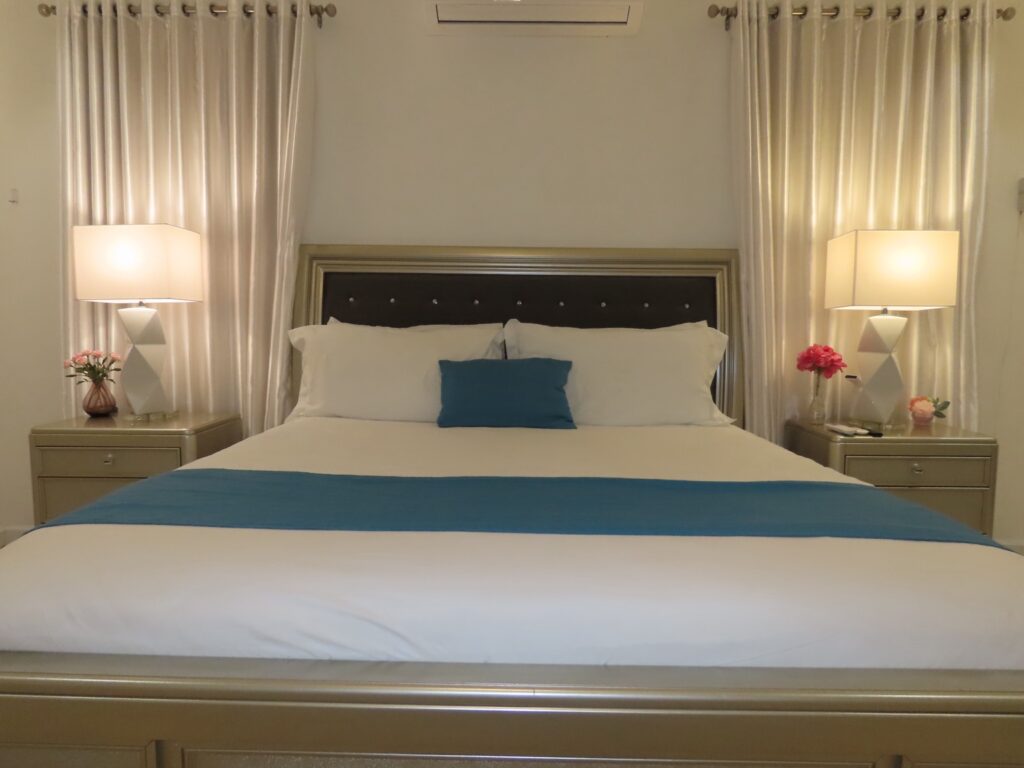 Guest house bedroom with white bedding and blue accent throw