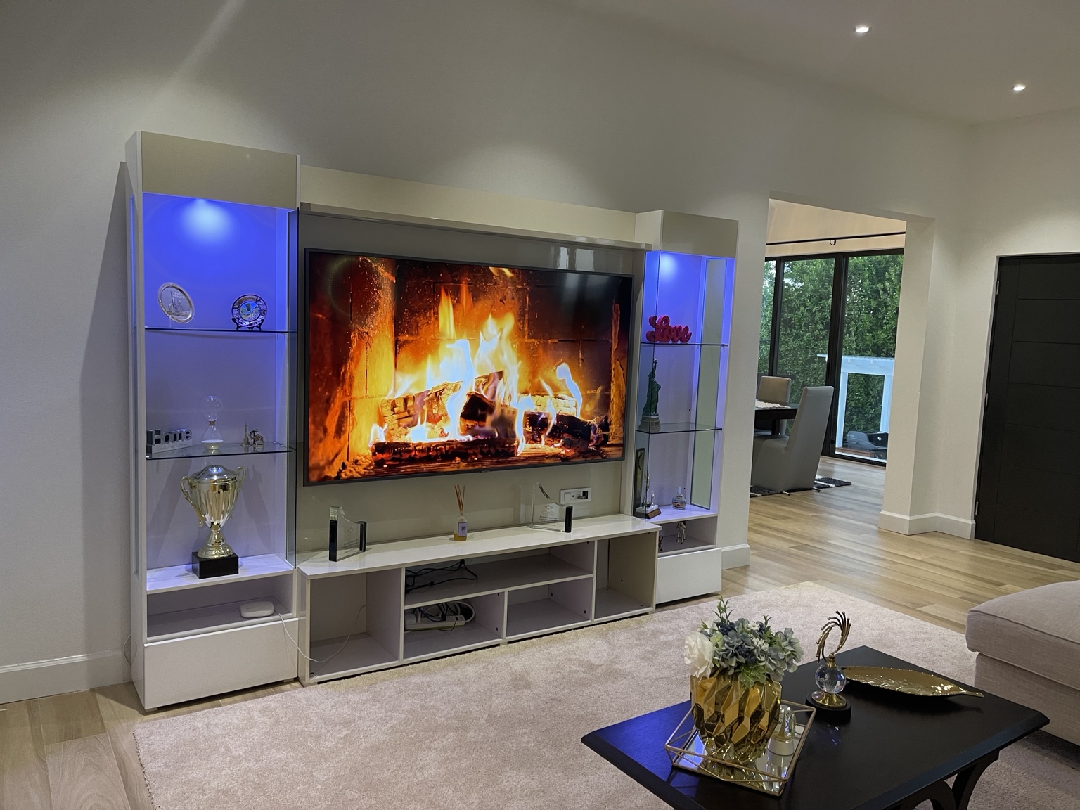 Guest house living room with large television and illuminated display shelves